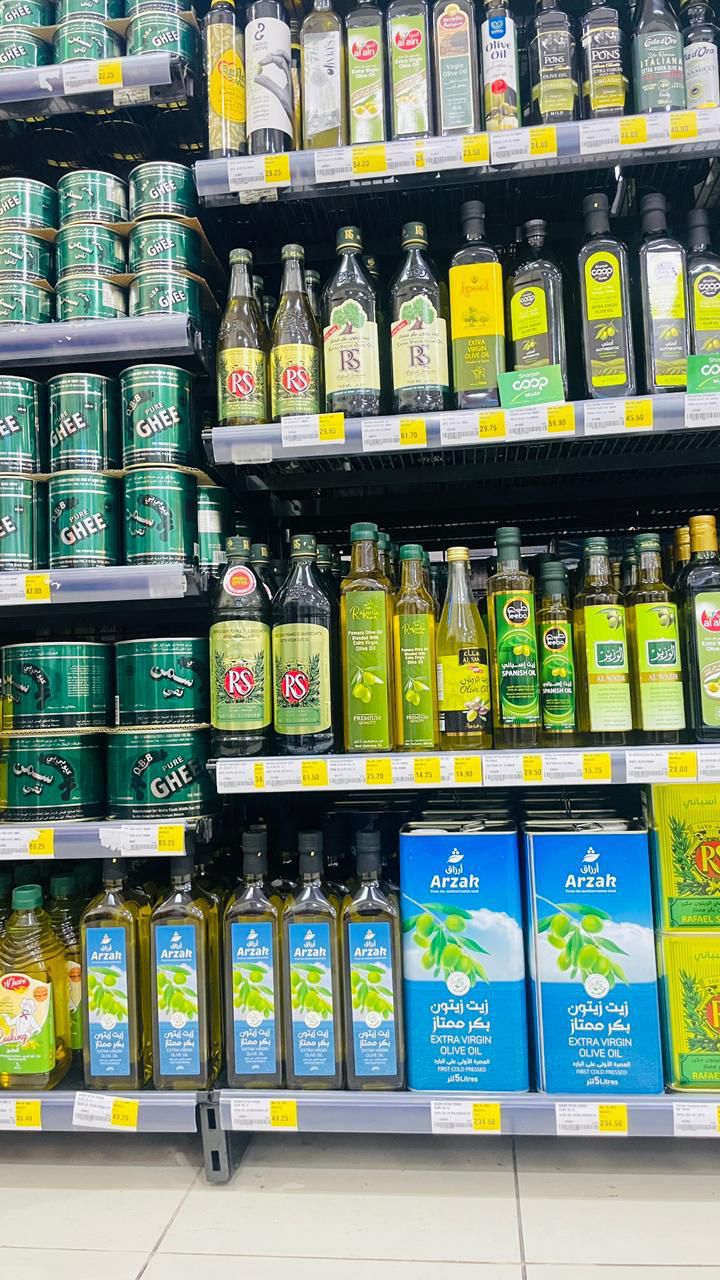 ARZAK 5 Liter blue cans alongside premium olive oil bottles in store