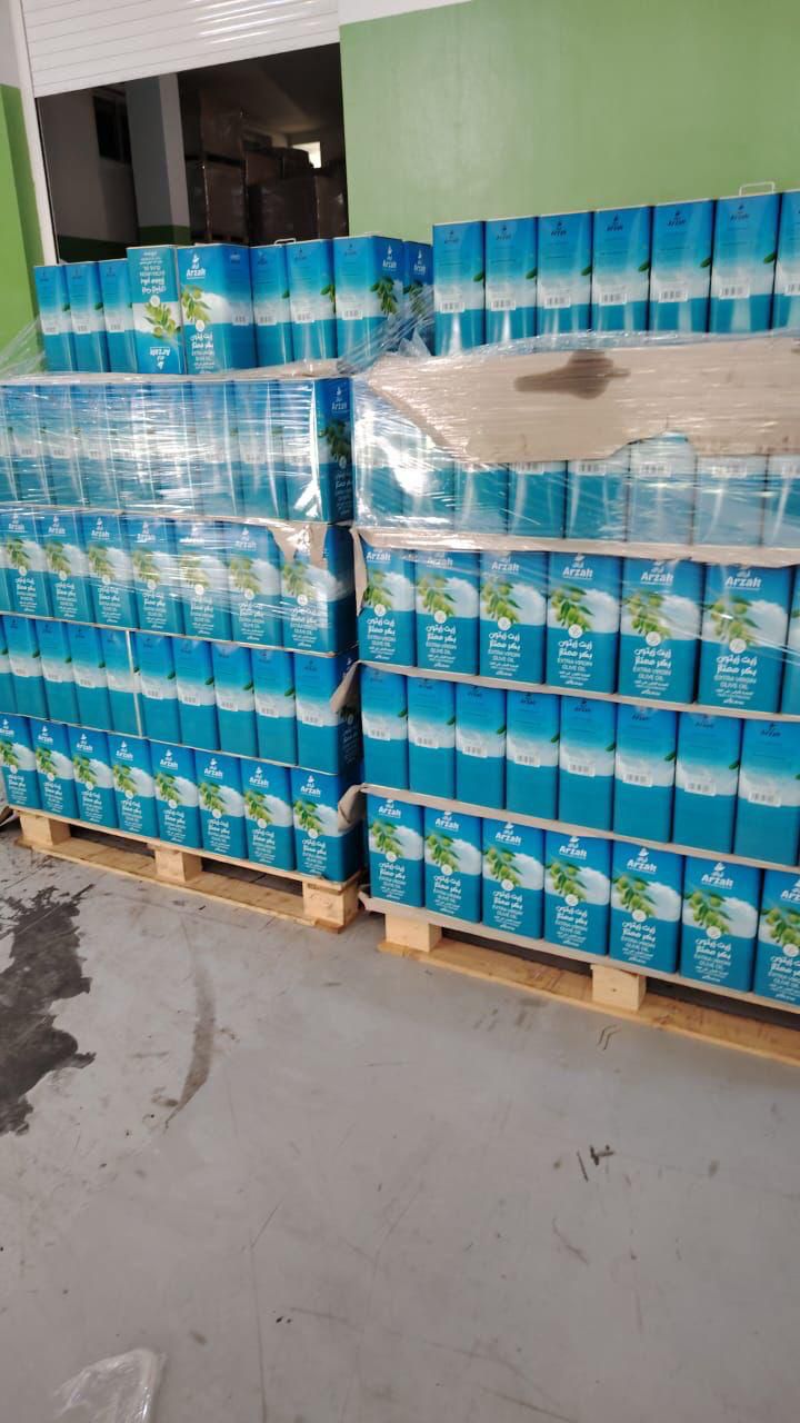 Stacked pallets of ARZAK olive oil cans wrapped for wholesale distribution